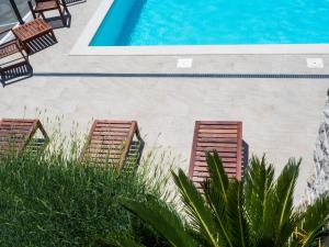 two chairs and a swimming pool in a yard at Apartments Bella Vista - Mlini in Mlini