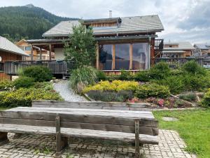 a wooden bench in front of a house at Auszeit-Hohentauern in Hohentauern