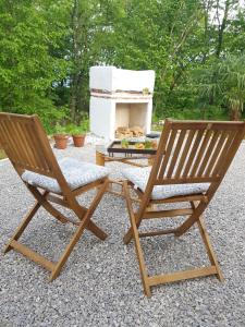 two wooden chairs and a table with a fireplace at Kuća za odmor Vladimir in Matulji
