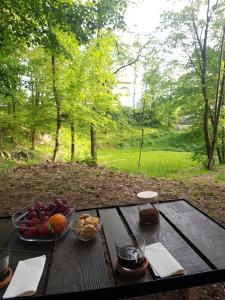 una mesa de picnic con un bol de fruta. en Kuća za odmor Vladimir en Matulji