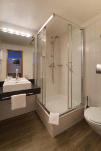 a bathroom with a shower and a toilet and a sink at Hotel Reinhardts in Bietigheim-Bissingen