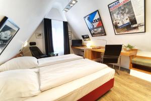 a bedroom with a bed and a desk with a computer at Hotel Reinhardts in Bietigheim-Bissingen