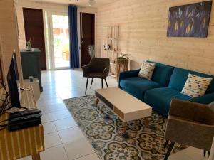 sala de estar con sofá azul y mesa en Le Cœur De La Mer, en Deshaies