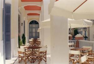 a patio with tables and chairs in a building at Tinion Hotel in Tinos