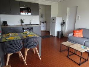 a kitchen and a living room with a table and chairs at T3 150 m de la plage, climatisation, piscine et parking privatif - Le Lavandou in Le Lavandou