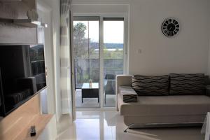a living room with a couch and a sliding glass door at Apartments Rena in Šibenik