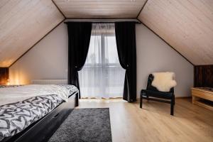 um quarto com uma cama, uma cadeira e uma janela em Brīvdienu māja Joki,Apartamenti Nr.2 em Ģipka