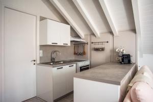 a kitchen with white cabinets and a sink at Angel Apartment in Fiskardo
