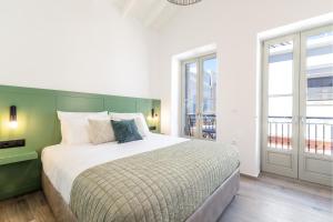 a bedroom with a large bed with a green headboard at Suite Christina in Symi