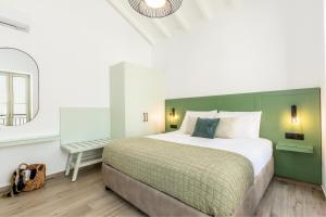 a bedroom with a large bed and a mirror at Suite Christina in Symi