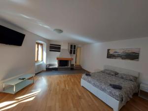 a large living room with a bed and a fireplace at L'angolo di Giulia in Castelletto di Brenzone