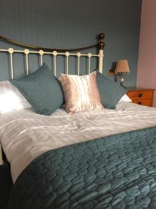 uma cama grande com muitas almofadas em cima em George & Dragon em Aysgarth