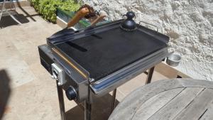 a black grill sitting on a stand next to a table at Semi-detached Adosado con Encanto -130 m2 - WiFi 600 Mb - Piscina Comunitaria - Patio Privado in Torremolinos