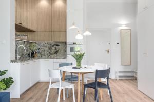 a kitchen and dining room with a table and chairs at Sanhaus Apartments - Apartament Mera z parkingiem i klimatyzacją in Sopot