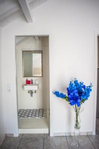 un jarrón lleno de flores azules en el baño en Angel Apartment, en Fiskardho