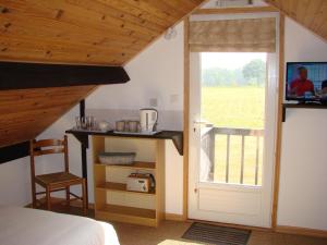 sypialnia z łóżkiem i drzwiami z oknem w obiekcie La Blanche Roche w mieście Sourdeval