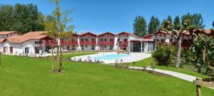 un gran edificio con un patio con piscina en Résidence Néméa Le Domaine d'Uhaina en Urrugne