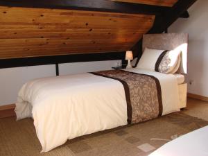 1 Schlafzimmer mit 2 Betten und Holzdecke in der Unterkunft La Blanche Roche in Sourdeval