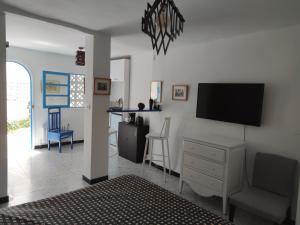 Suite à sidi bou Saïd في سيدي بو سعيد: غرفة معيشة مع تلفزيون بشاشة مسطحة على جدار