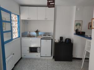 una pequeña cocina con armarios blancos y microondas en Suite à sidi bou Saïd, en Sidi Bou Saïd