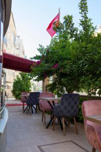 een patio met tafels en stoelen en een parasol bij Toprak Apart Otel in Antalya