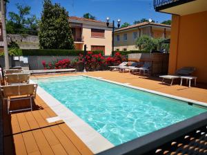 uma grande piscina com cadeiras e uma casa em Appartamento Alessio em Bardolino