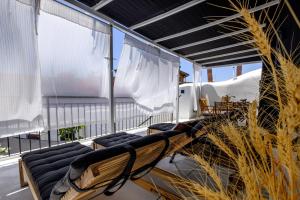 a room with chairs and curtains on a balcony at Casa BOHO in Alaminos