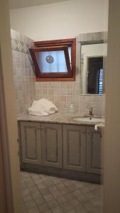 La salle de bains est pourvue d'un lavabo et d'un miroir. dans l'établissement residence approdo, à Cannigione