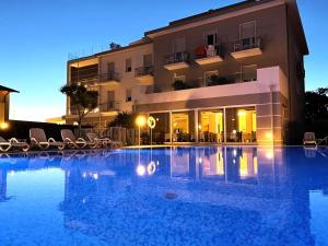 um hotel com piscina em frente a um edifício em Hotel Paradiso em Bardolino