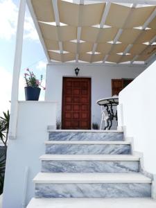 a staircase leading to a house with a wooden door at Seatinview Lodges in Mikonos