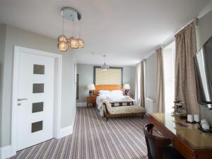 a bedroom with a bed and a desk and a room with a bed sidx sidx at Seaspray Rooms in Bexhill