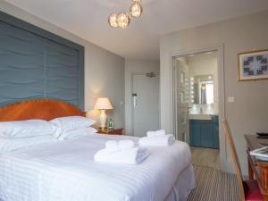 a bedroom with a large white bed with towels on it at Seaspray Rooms in Bexhill