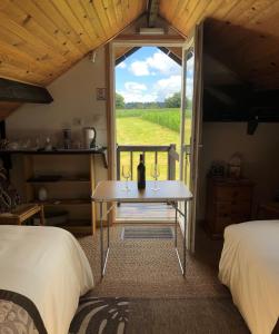 Zimmer mit 2 Betten und einem Tisch mit Fenster in der Unterkunft La Blanche Roche in Sourdeval