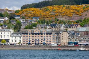 a group of buildings on the shore of a body of water at Esplanade Court Holiday Apartments in Oban