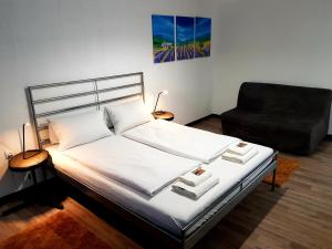1 dormitorio con 1 cama y 1 silla negra en YourSweetHome, en Berlín