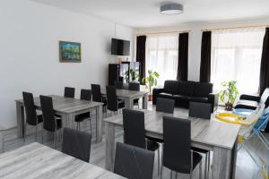 a living room with tables and chairs and a dining room at Keresztúri Vendégház in Bodrogkeresztúr