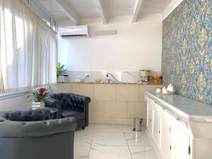 ein Wohnzimmer mit 2 Stühlen und eine Küche in der Unterkunft Dimora San Biagio Suites&Apartment in Lecce