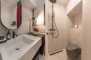 Un baño blanco con lavabo y ducha. en Beachfront Deluxe B&B, en Makarska 32 fotos más