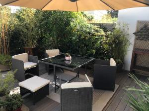 塞特港的住宿－Villa Marcenac 45 m2, jardin, parking, wifi, netflix，庭院配有桌椅和遮阳伞。