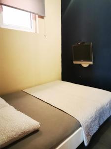 Un dormitorio pequeño con una cama y un televisor en la pared. en Nest, en Belgrado