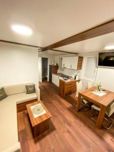 ein Wohnzimmer mit einem Tisch und einer Küche in der Unterkunft Star 1 Floating House, Marina Portorož in Portorož
