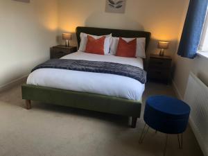 a bedroom with a large bed with red pillows at Roundhay House in Leeds