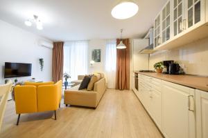 cocina con sillas amarillas y sala de estar. en The Comfy Spot - 1 BR-Apartment & Parking Included in North Business Area, en Bucarest