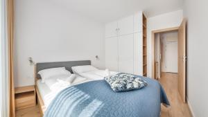 a bedroom with a large bed with a blue blanket at Apartamenty Sun & Snow Mielno Olimpijska z sauną in Mielno