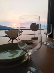 a wine glass sitting on a table next to a window at Marmari megali ammos oasis studio's in Ayía Marína +37 photos
