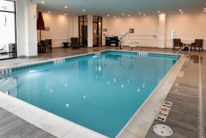une grande piscine d'eau bleue dans l'établissement Cambria Hotel Detroit-Shelby Township, à Shelby