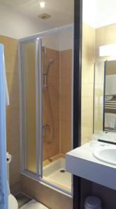 La salle de bains est pourvue d'une douche et d'un lavabo. dans l'établissement Le Fair Play, à Léon