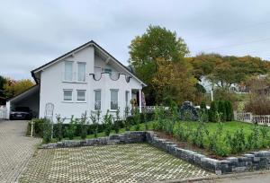 une maison blanche avec un jardin en face dans l'établissement Wohlfühl-Apartment Bergwinkel, à Schlüchtern