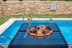 a plate of food on a table in a swimming pool at Marinas Villas in Amoudara Herakliou