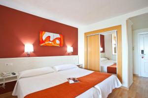 a bedroom with a large bed with a red wall at Ona Princesa Playa in Marbella
